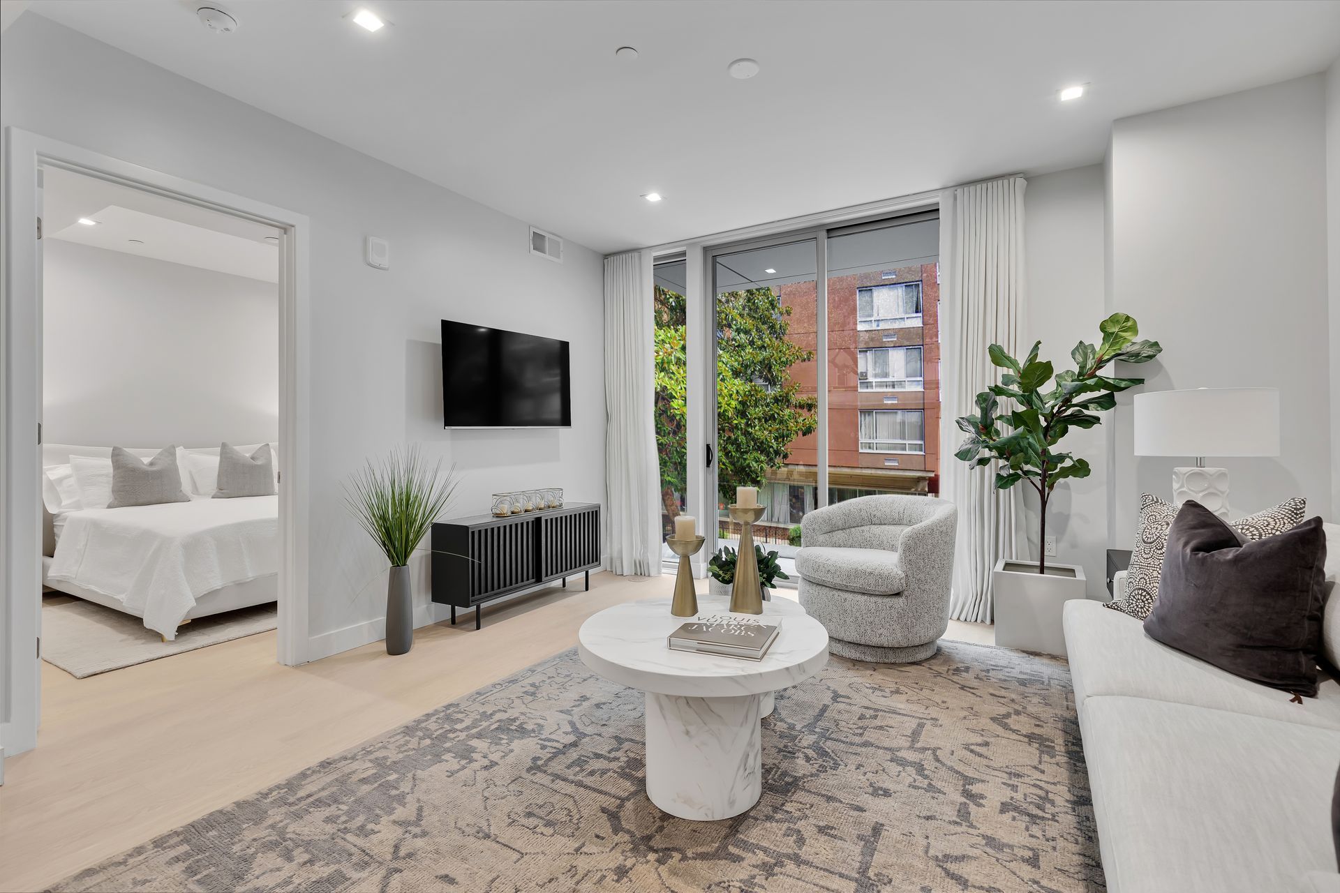 A living room with a couch , chair , coffee table and television.