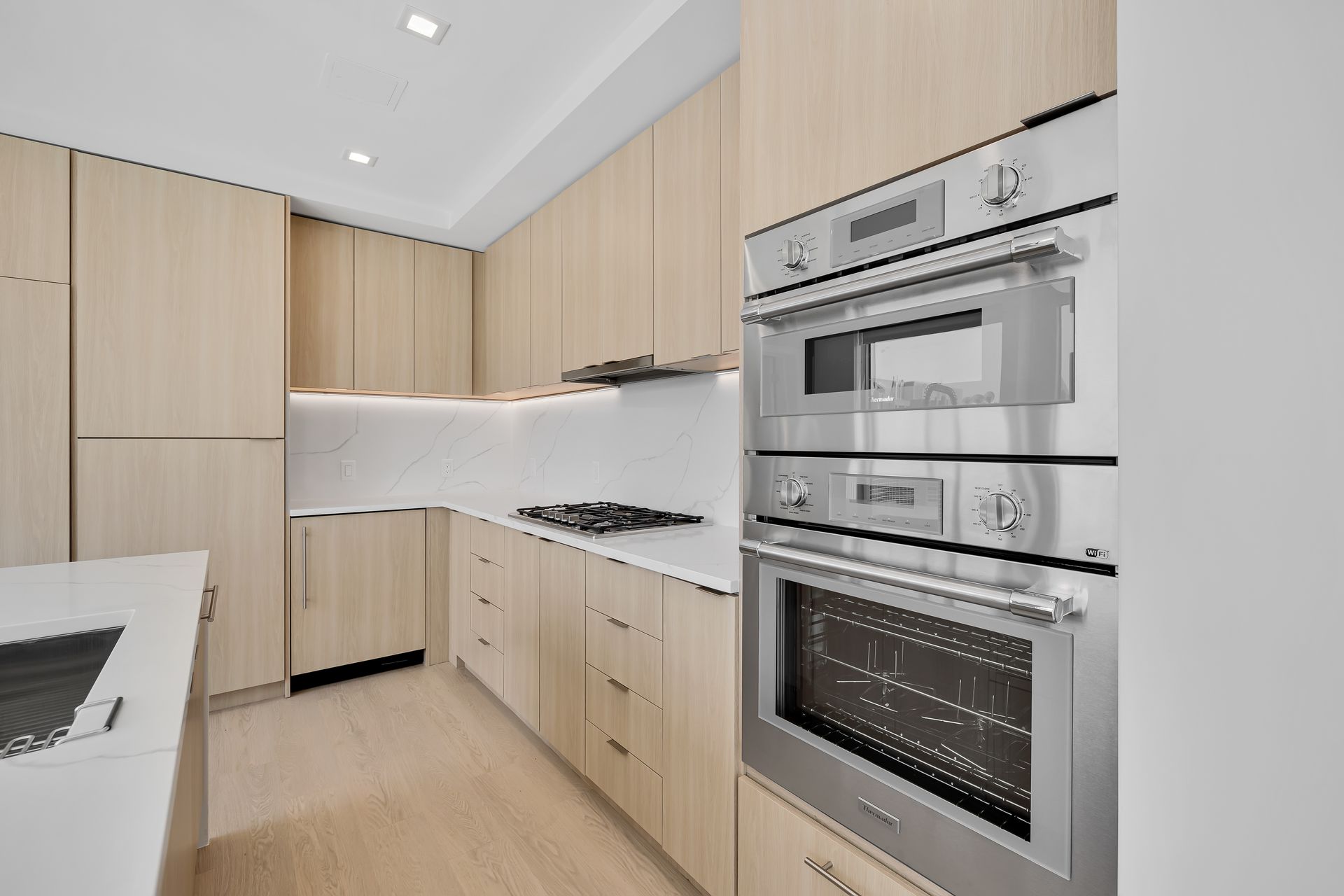 A kitchen with stainless steel appliances and wooden cabinets.