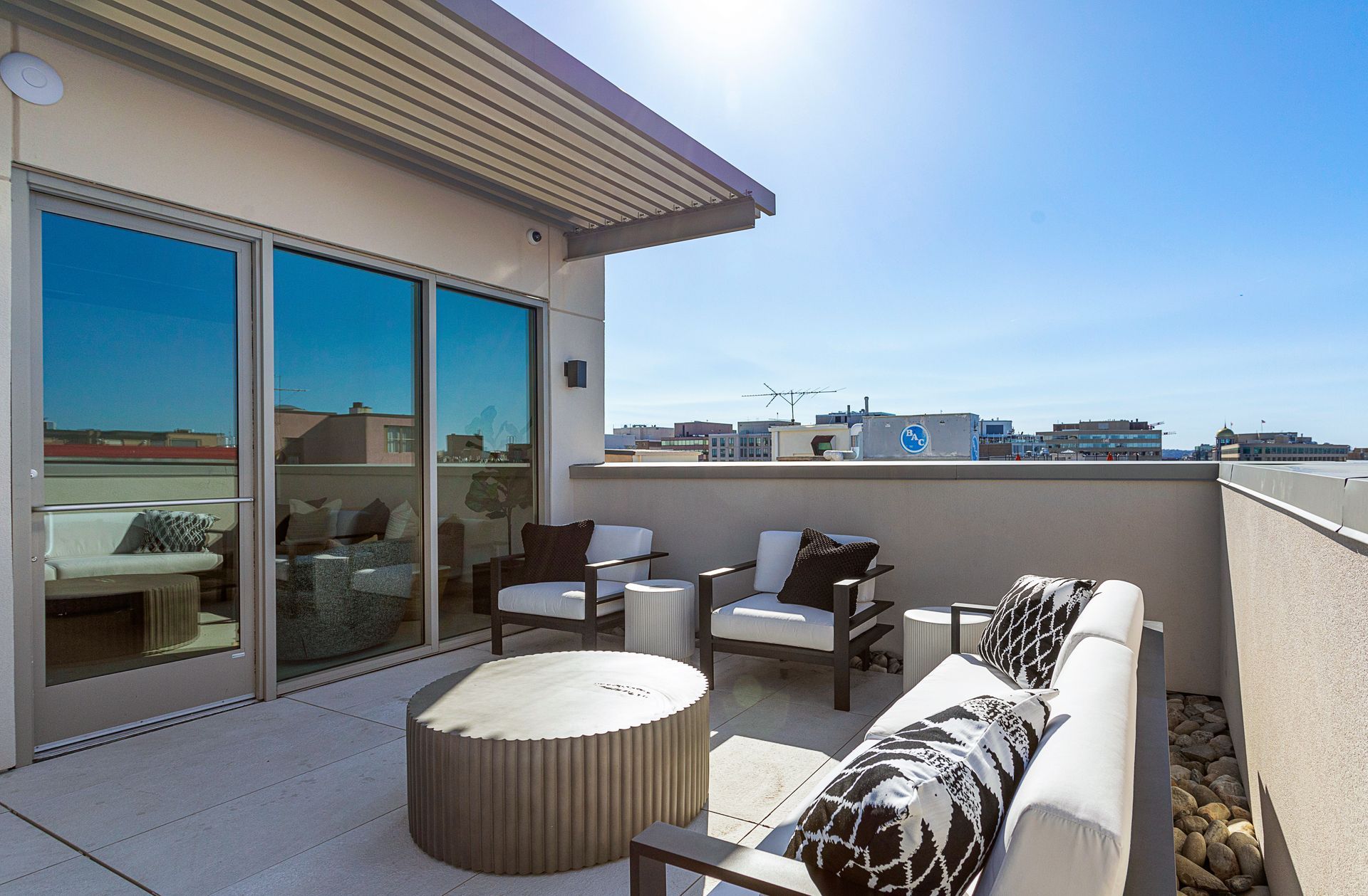 A balcony with a couch and chairs and a table