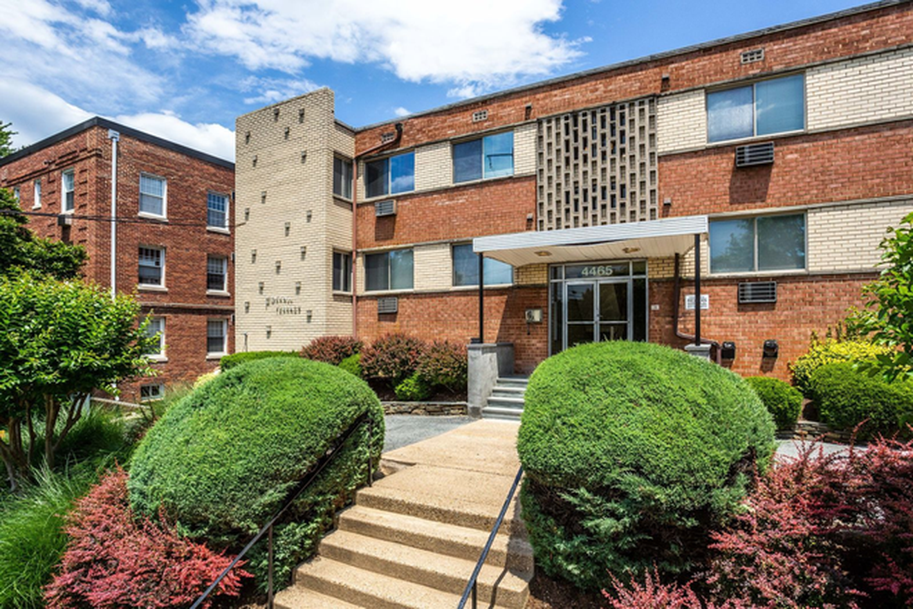 A large brick apartment building with stairs leading up to the entrance.