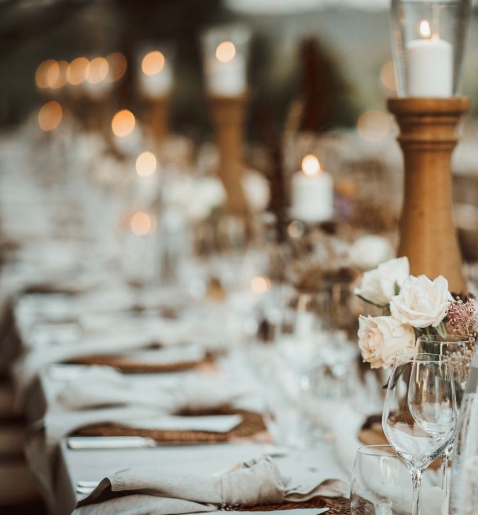 Elegante apparecchiatura da tavola con fiori, candele e bicchieri.