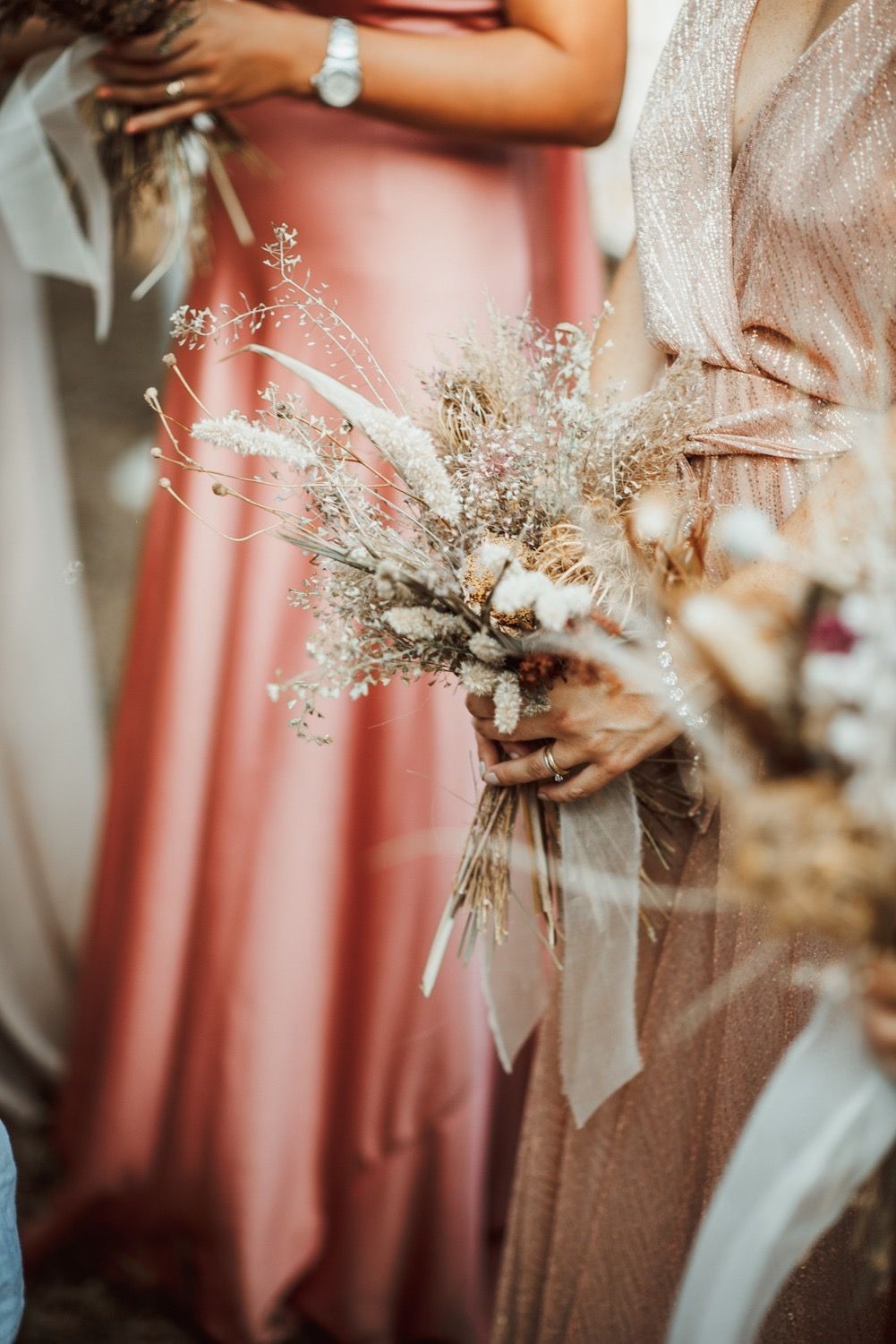 Damigelle con bouquet in mano, vestite di rosa. Ambientazione della cerimonia.