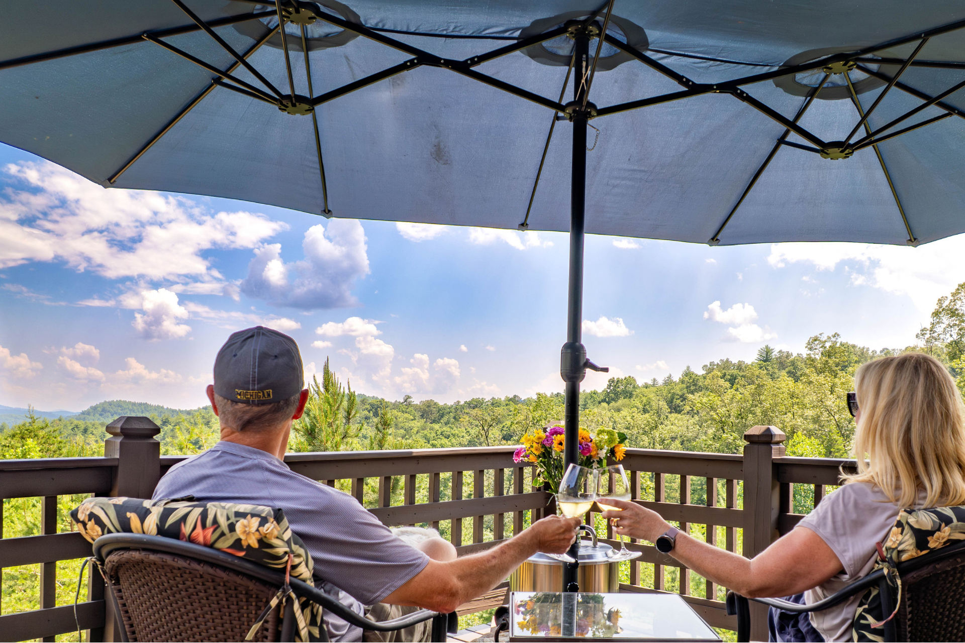 Couple enjoying long-range mountain views from the deck of a mountain home