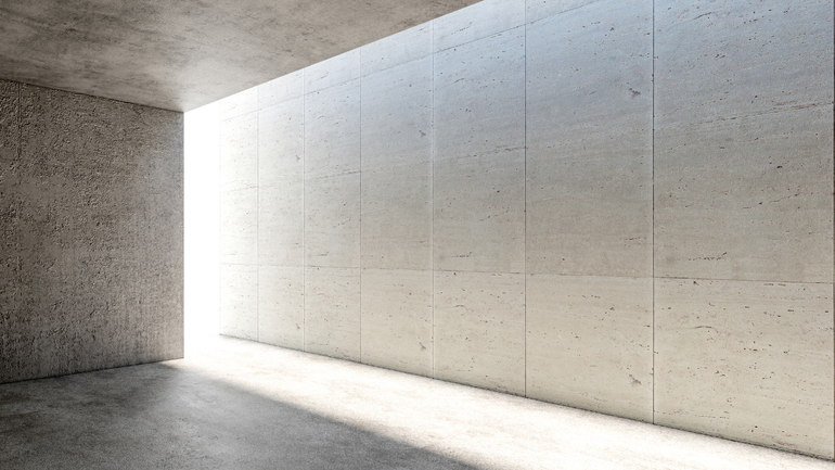 A fully cement room with light coming out of the entrance