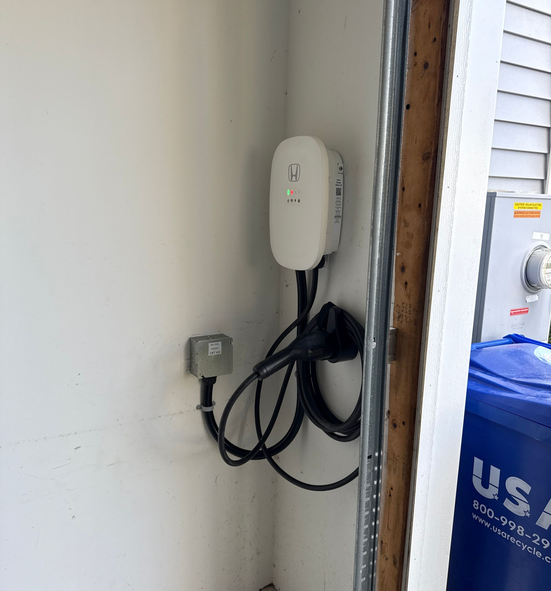 White GFCI electrical outlet with red reset button on a textured wall.