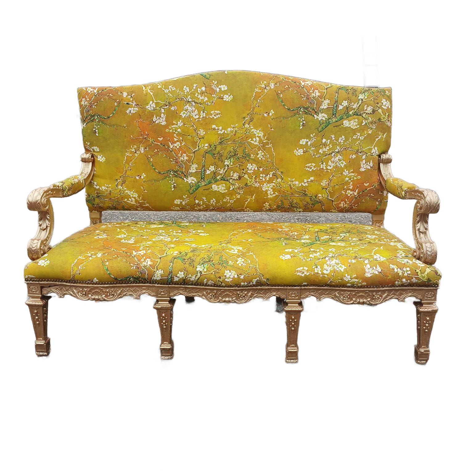 Ornate yellow couch with floral pattern, gold trim, and scrolled arms.