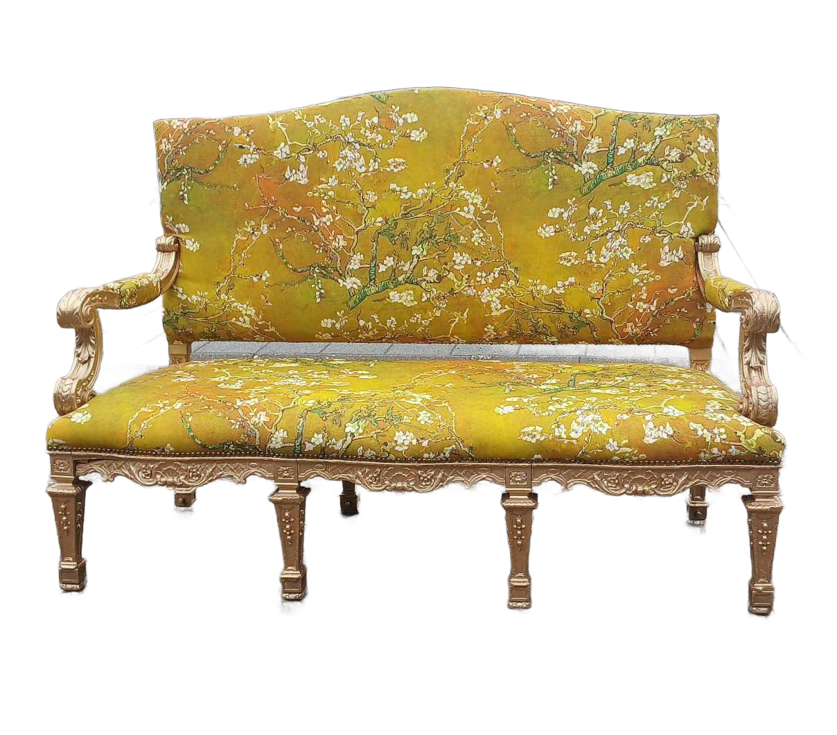 Yellow floral-patterned sofa with gold trim, ornate arms and legs, isolated on white.