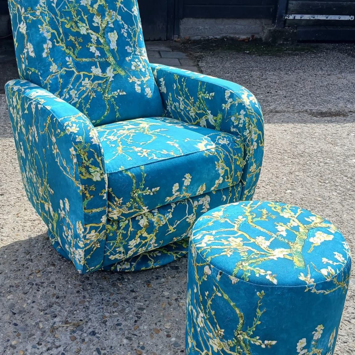 Draaibare fauteuil en voetenbank met blauwgroene stof, wit en groen bloemenpatroon, voor buiten.