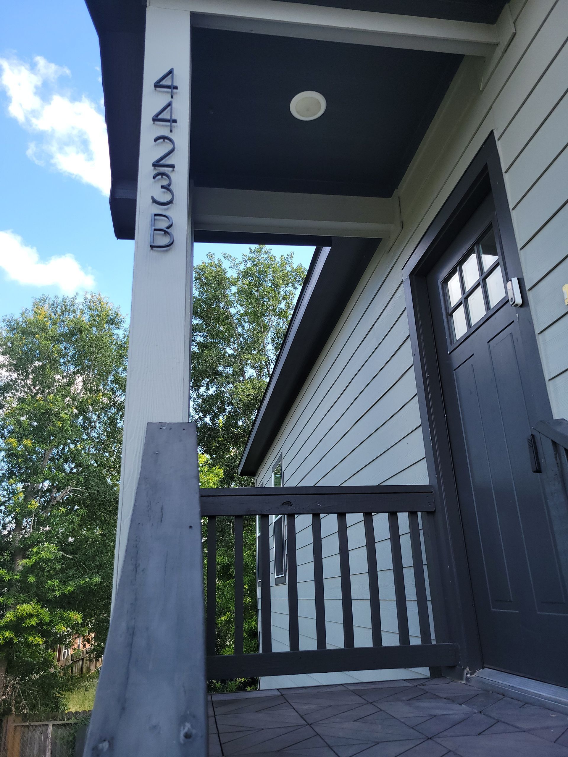 House entrance with address numbers 4233 on a white column, gray door and trim.
