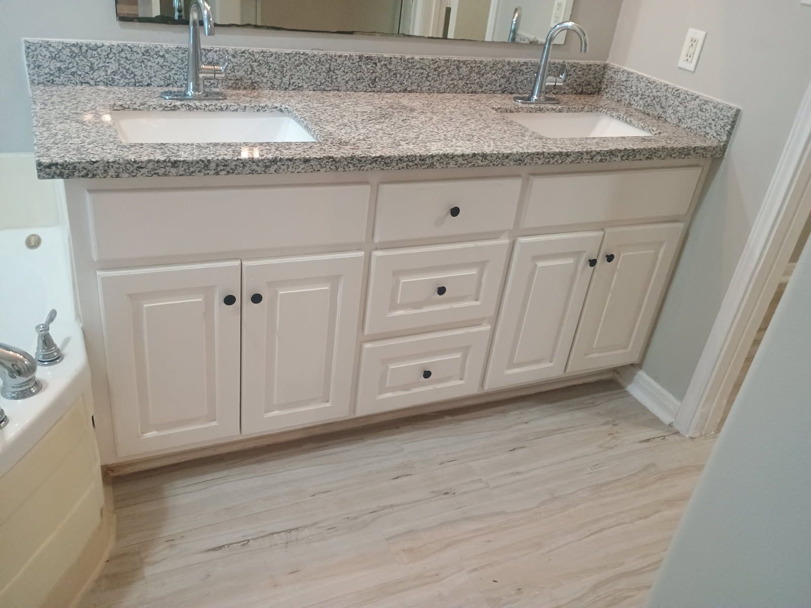 White double sink vanity with granite countertop in a bathroom.