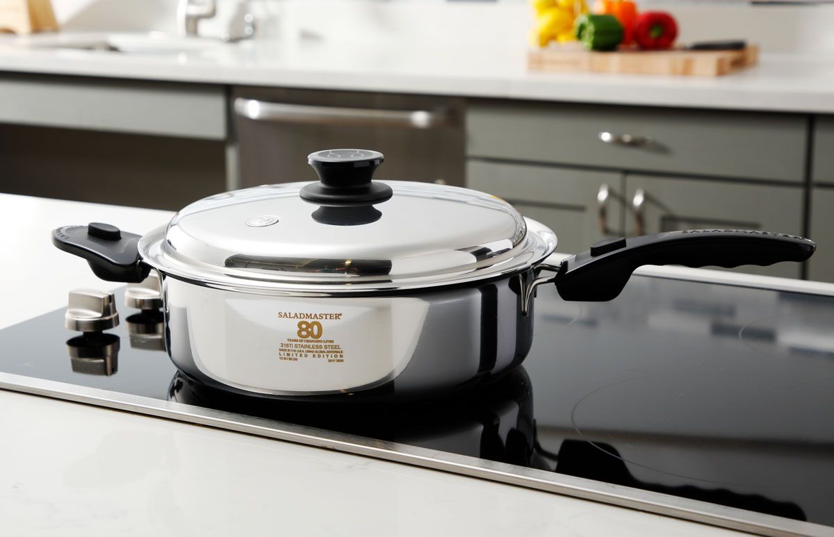 Shiny lidded saucepan on a black stovetop in a modern kitchen