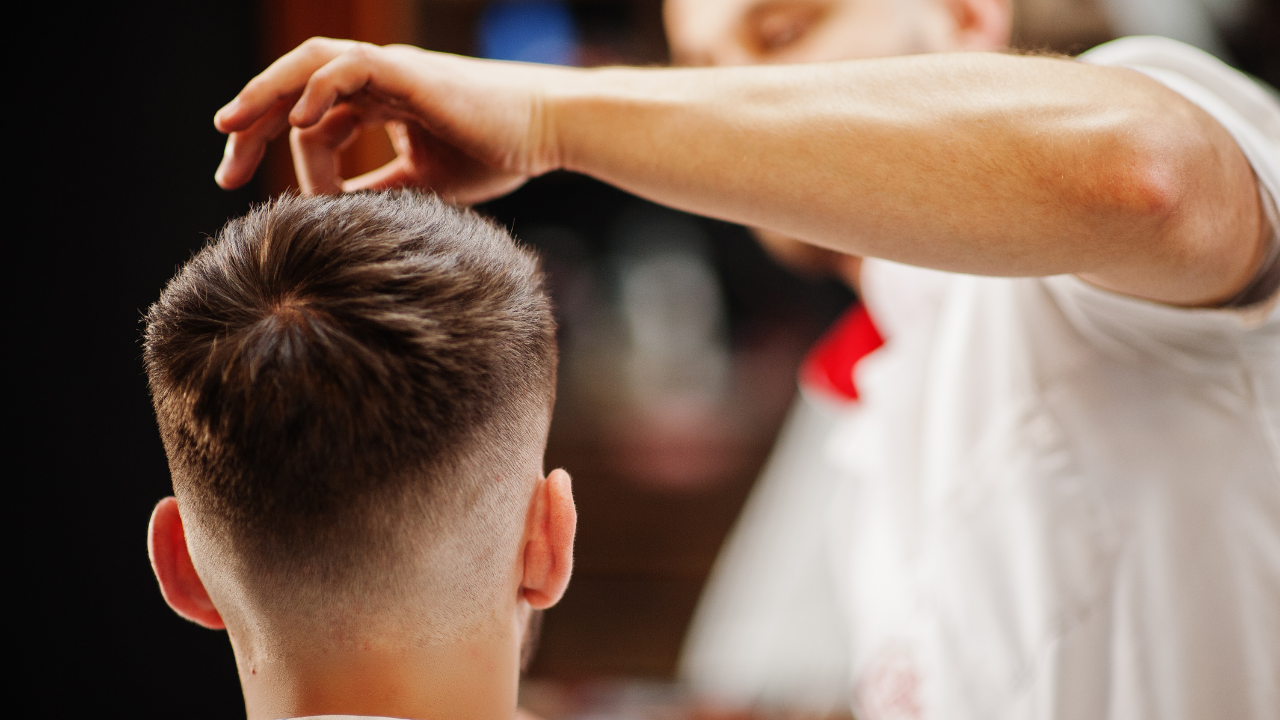 Barber trimming a man's hair, close-up on the back of the head.