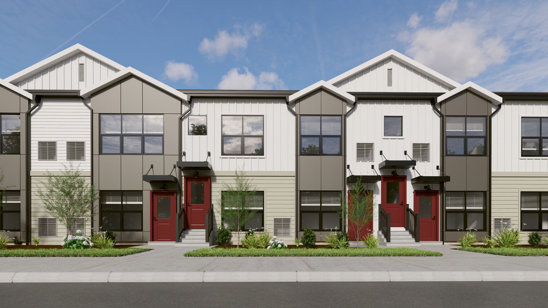 A row of modern townhomes with red doors, grey and white siding, gabled roofs, and small front yard landscaping.