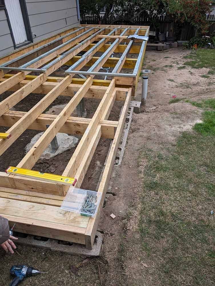 A Wooden Deck is Being Built in the Backyard of a House — Chandolin Construction in Bathurst, NSW
