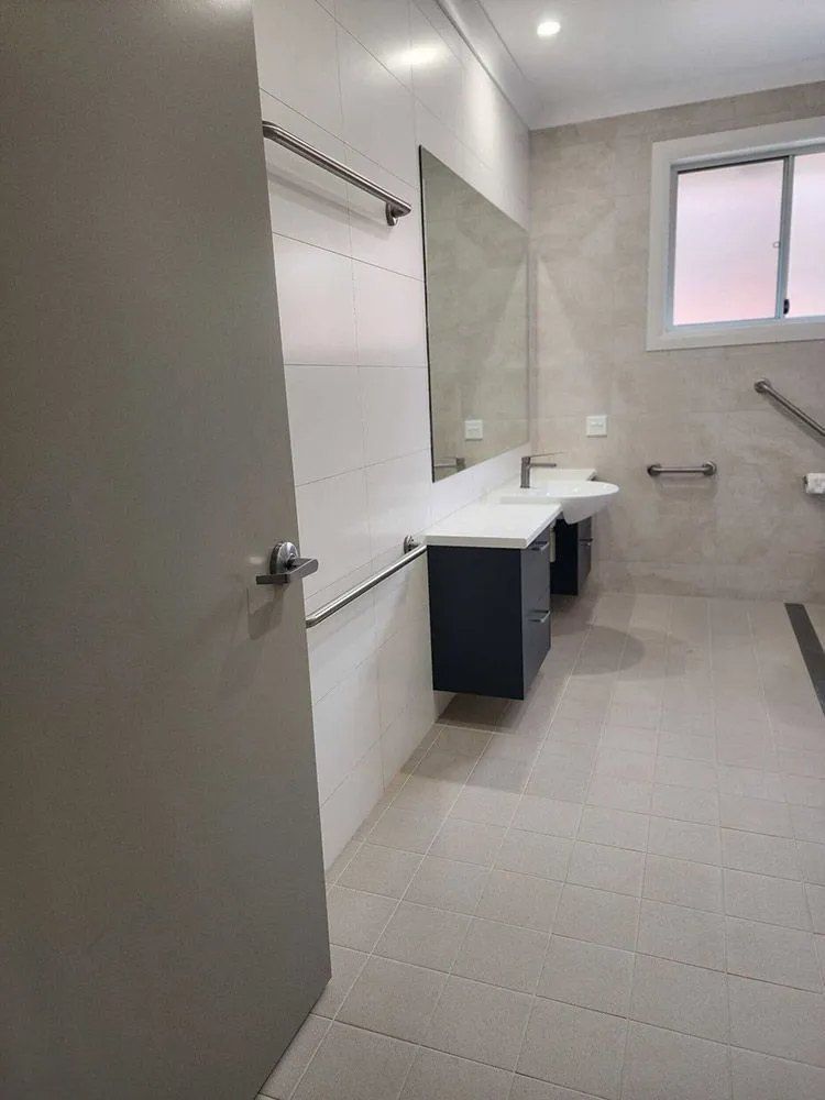 A Bathroom With Two Sinks , a Mirror and a Window — Chandolin Construction in Bathurst, NSW
