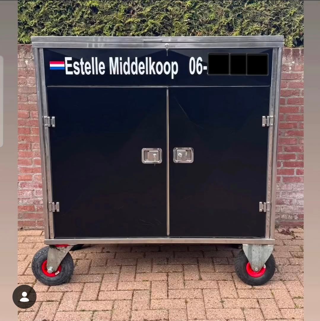 Een zwart voertuigoppervlak met de Nederlandse vlag en de witte tekst 