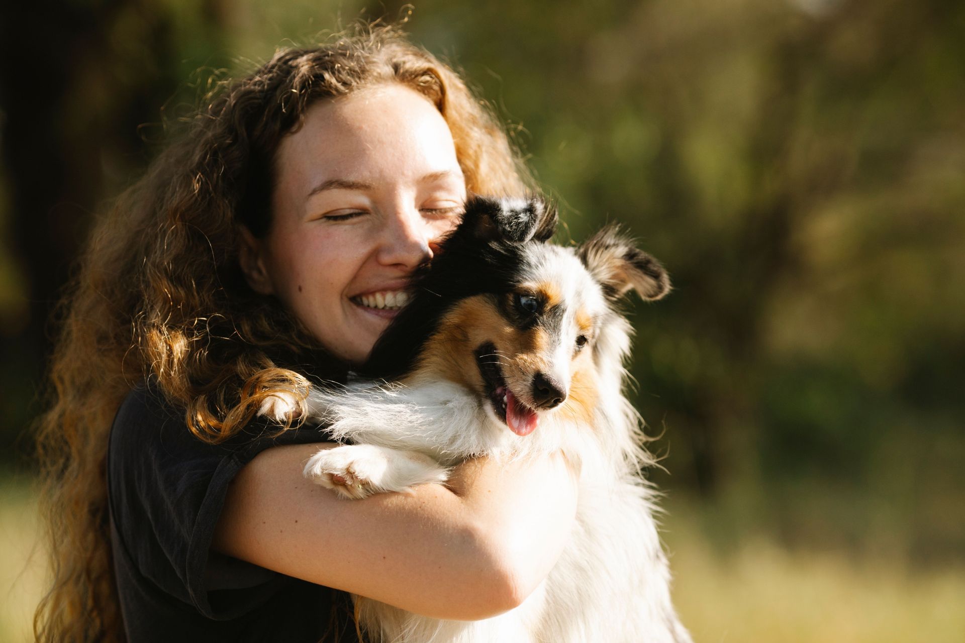 A woman is laying on a couch with a dog.