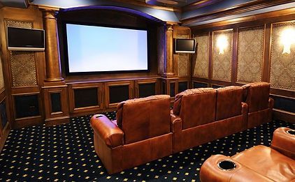A home theater with a large screen and brown leather seats