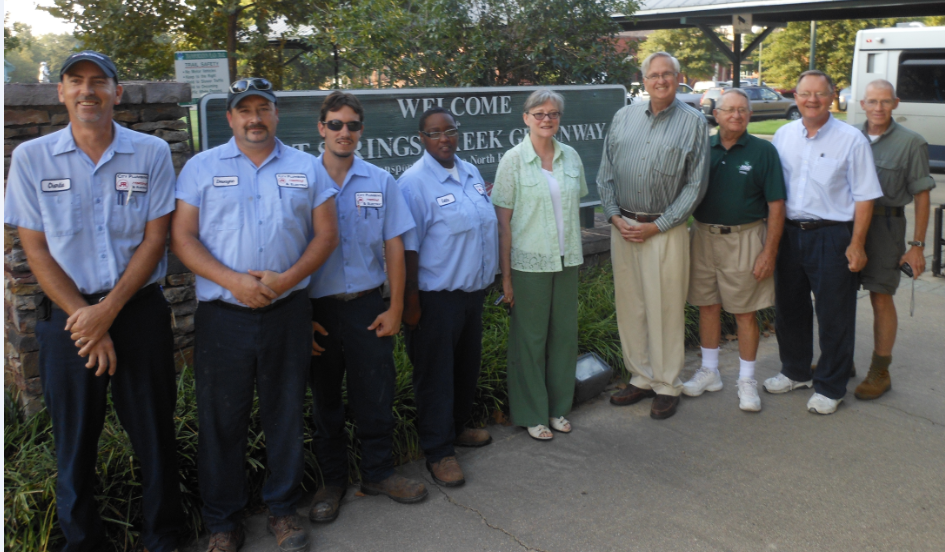 A group of people standing in front of a welcome sign