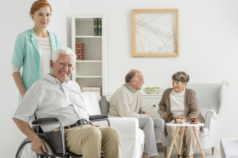 Elder happy man sitting in wheelchair in day room