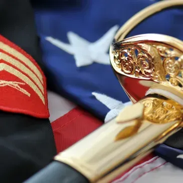 Decorative sword with gold hilt over folded American flag fabric