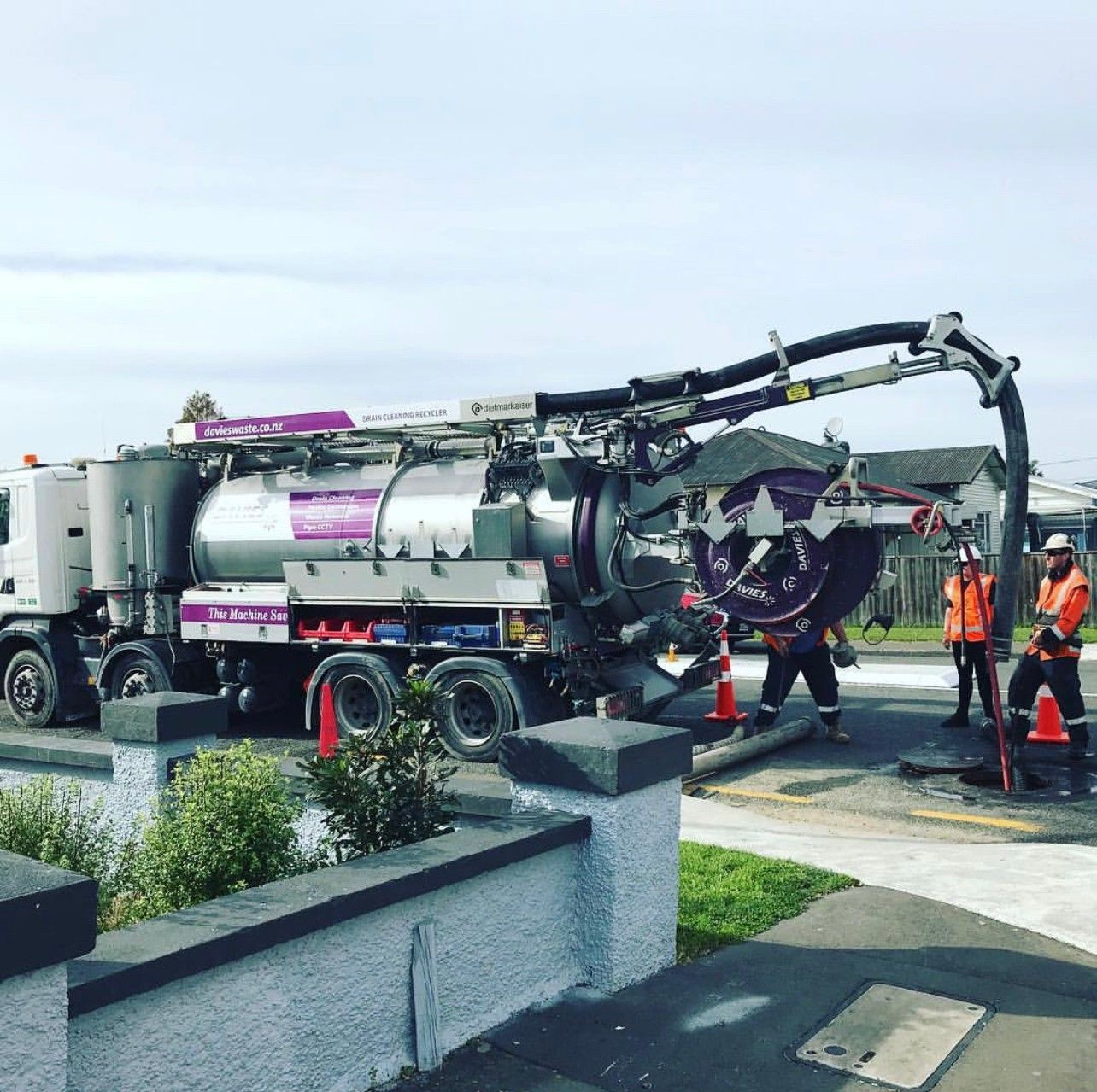 A vacuum truck is parked on the side of the road.