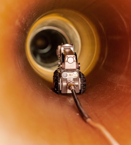 A robot is crawling through a pipe with a camera attached to it.