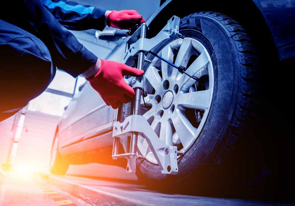 Mechanic Doing Wheel Alignment Work At Repair Station