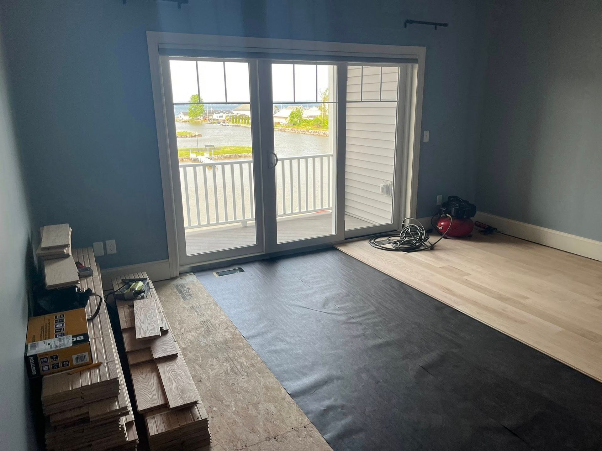 A room with a wooden floor and a sliding glass door.
