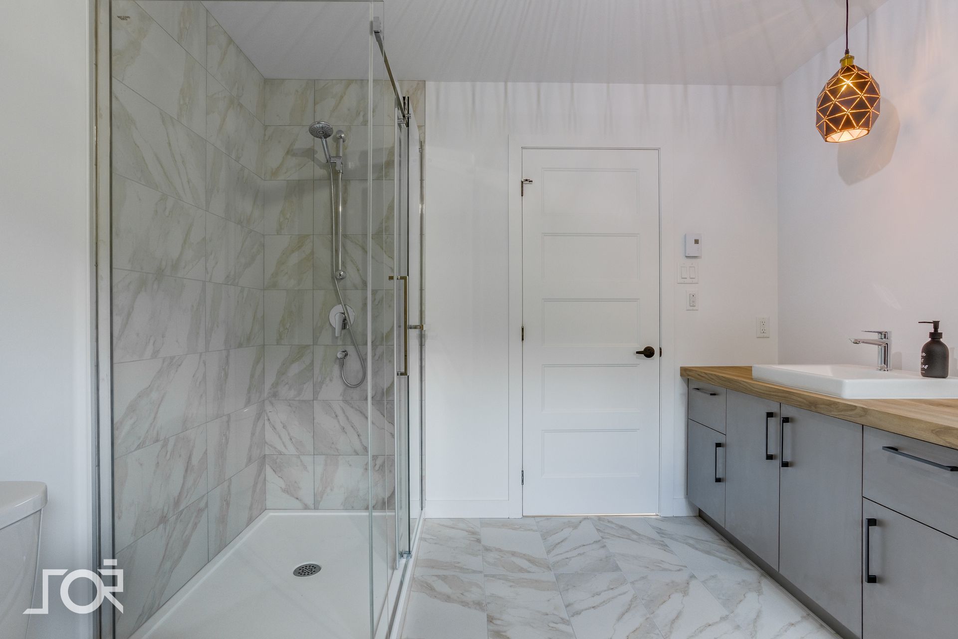 Une salle de bain avec une douche à l'italienne et un lavabo