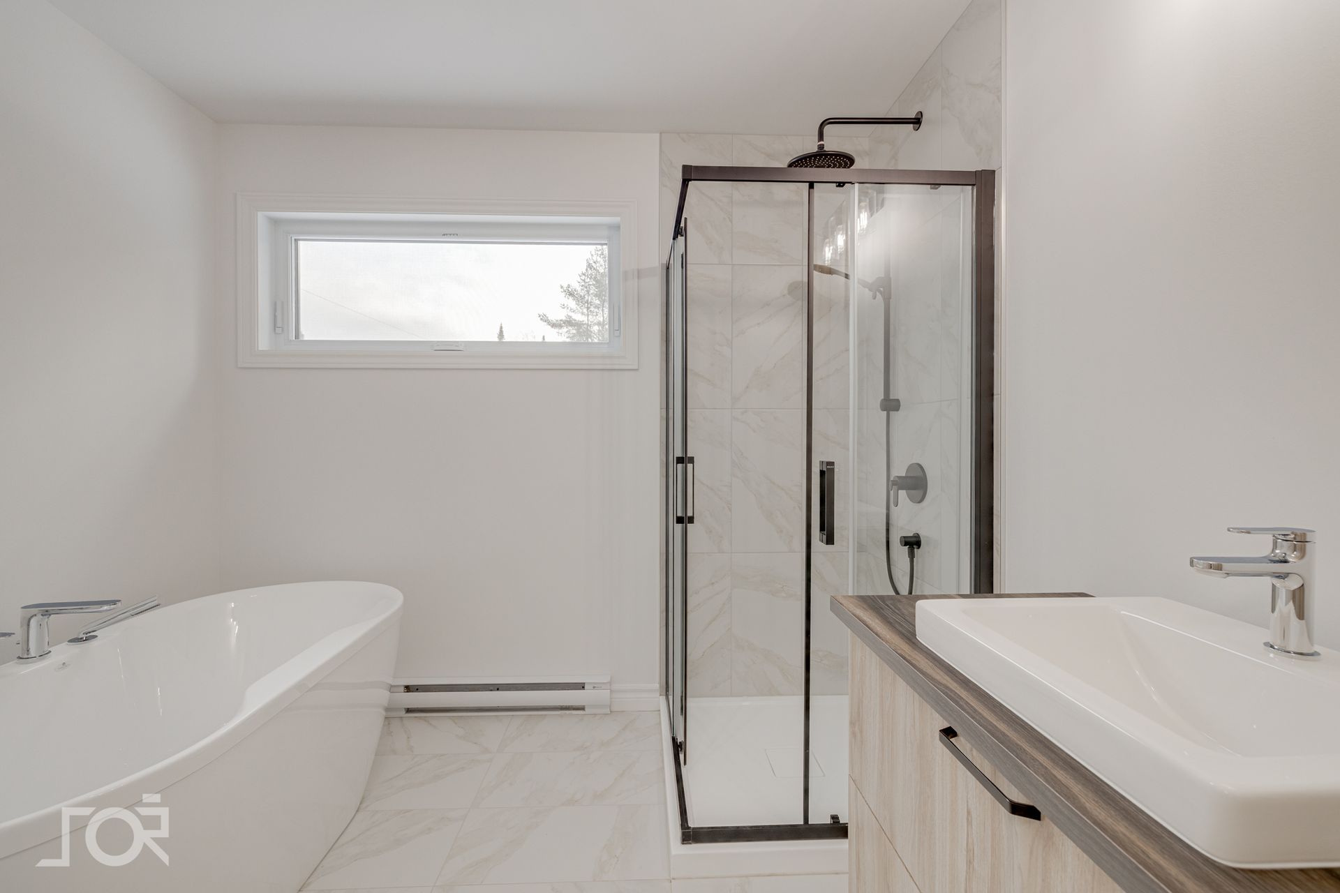 Salle de bains moderne blanche avec douche, baignoire et meuble-lavabo avec fenêtre.