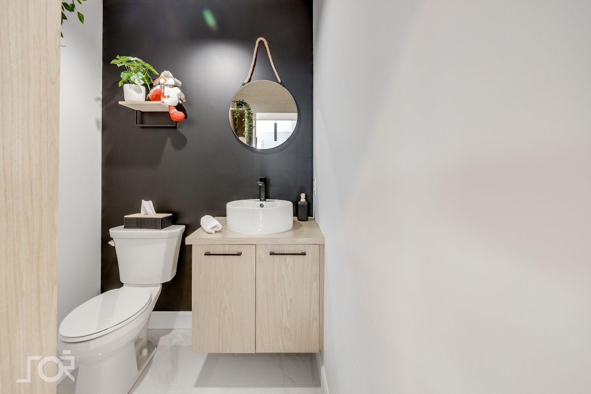 Une salle de bain avec WC, lavabo et miroir.