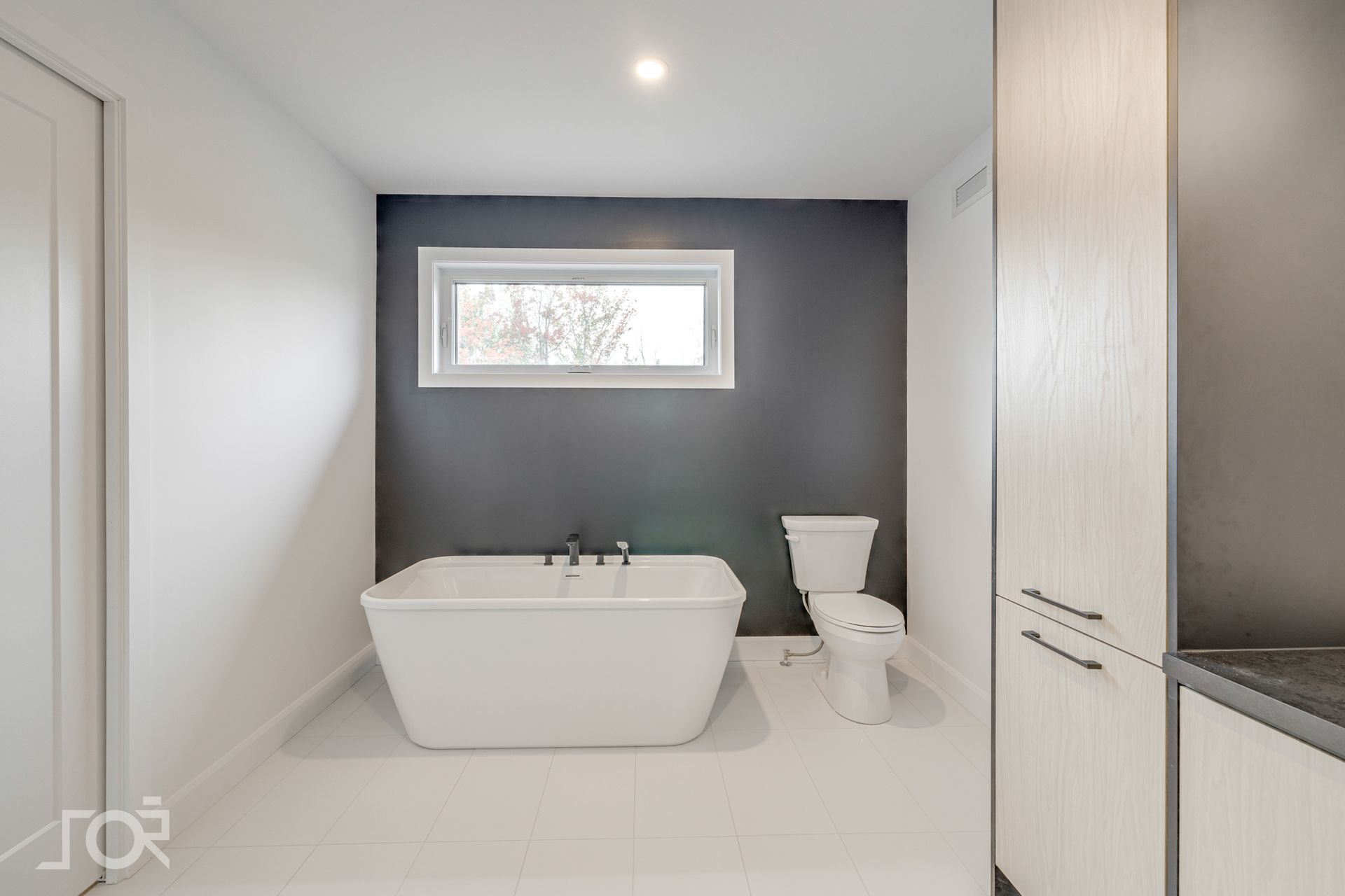 Une salle de bain avec baignoire, toilettes et fenêtre