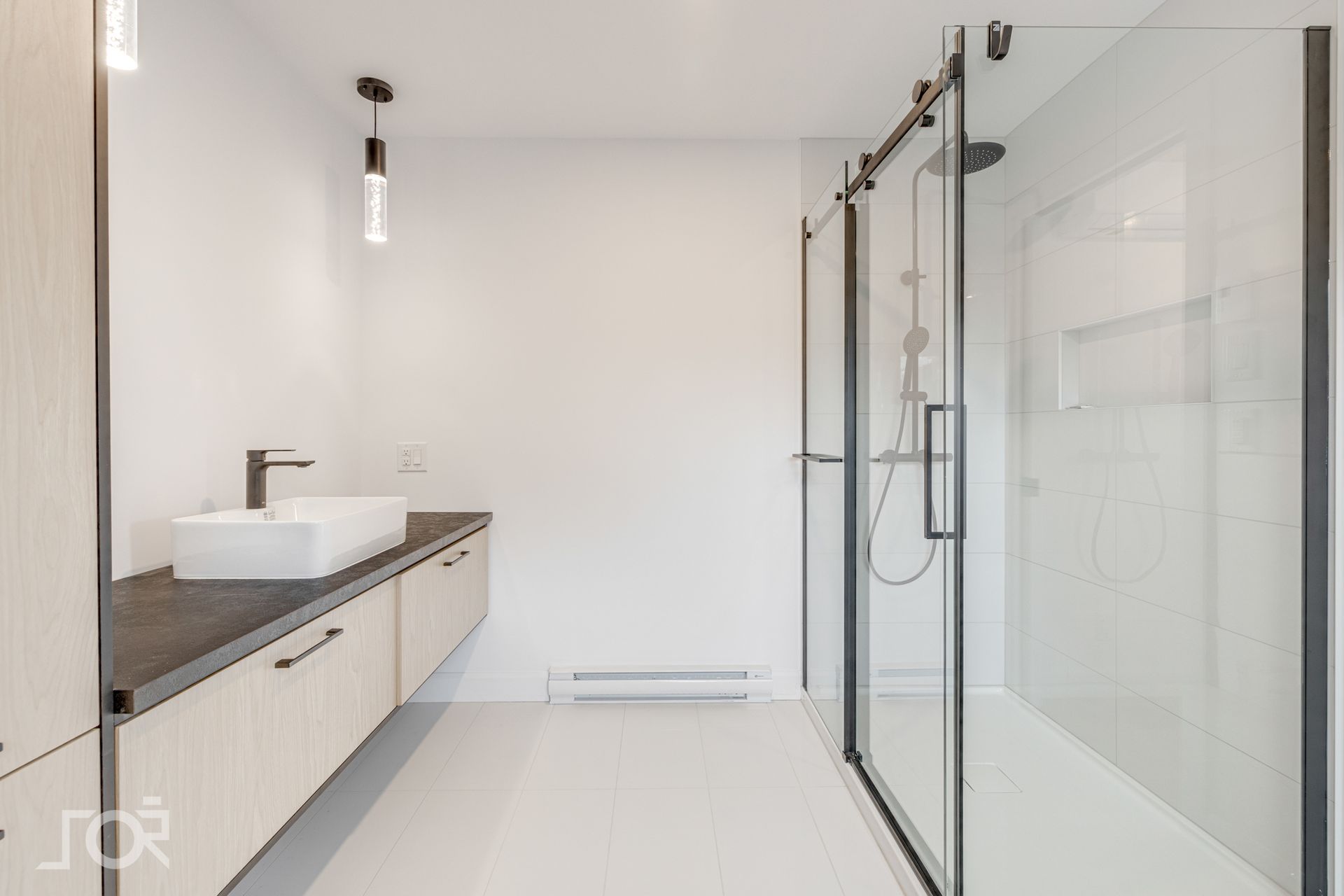 Une salle de bain avec un lavabo et une douche avec portes coulissantes en verre.