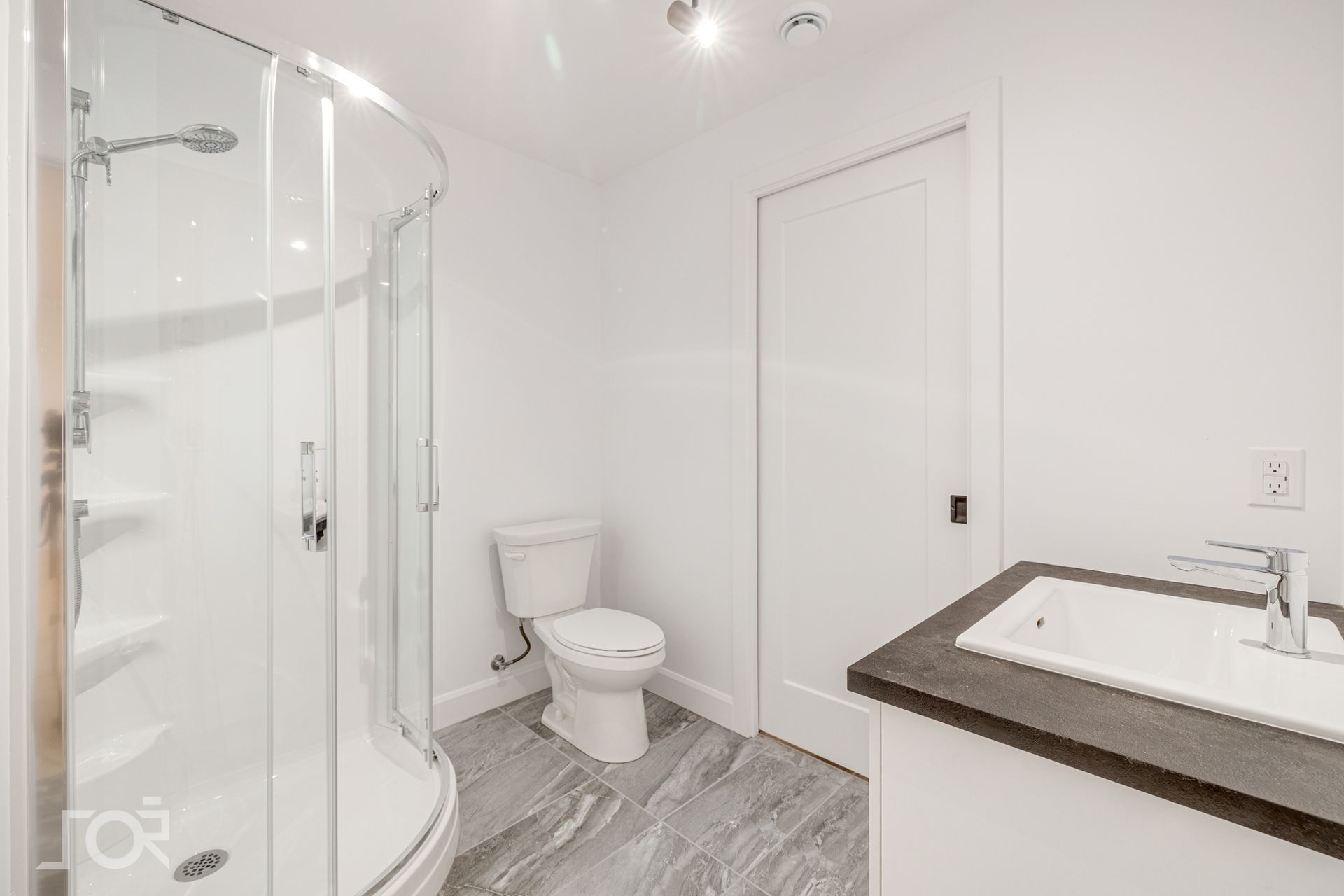 Une salle de bain avec WC, lavabo et douche.