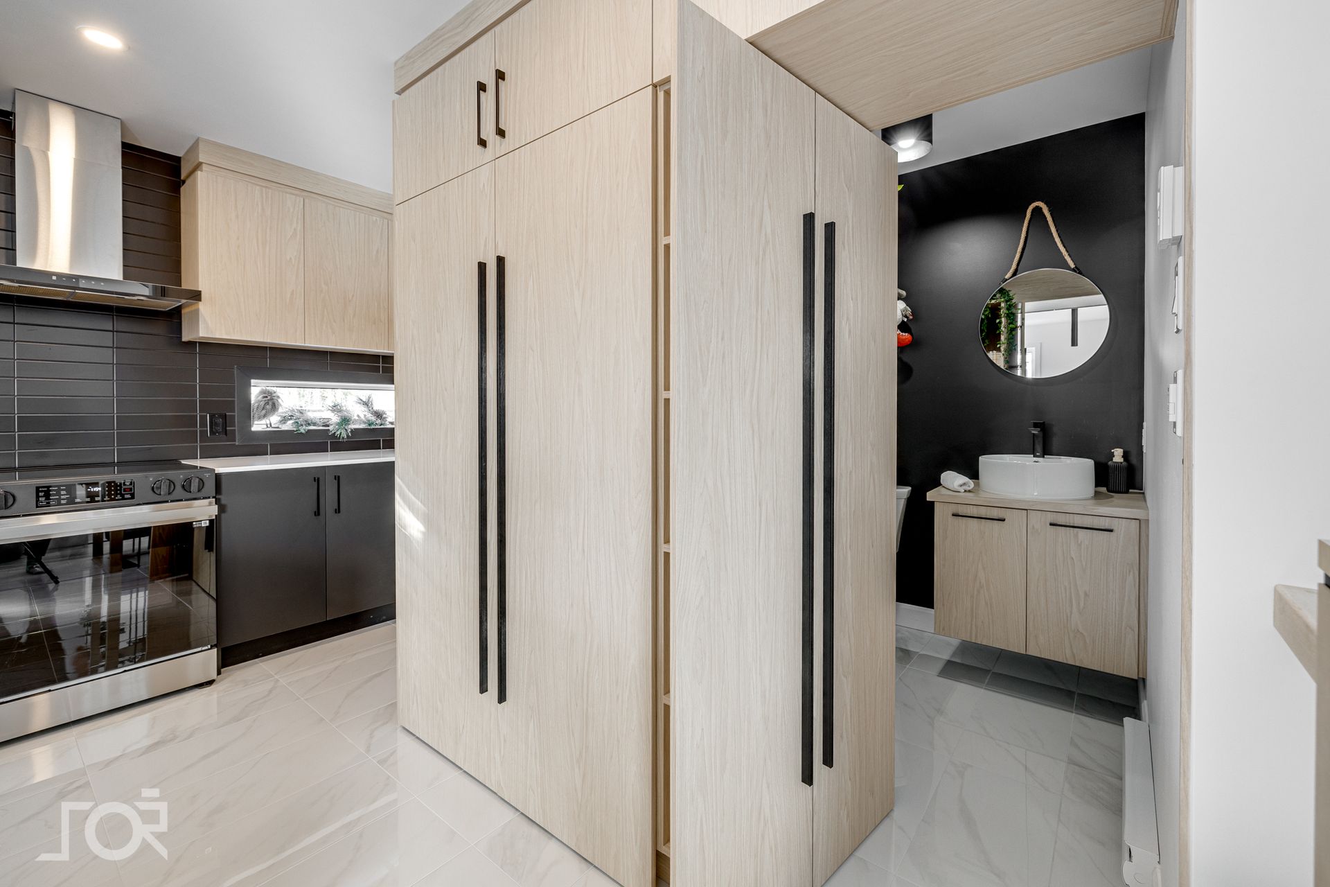 Une cuisine avec des armoires en bois et une salle de bain avec lavabo.