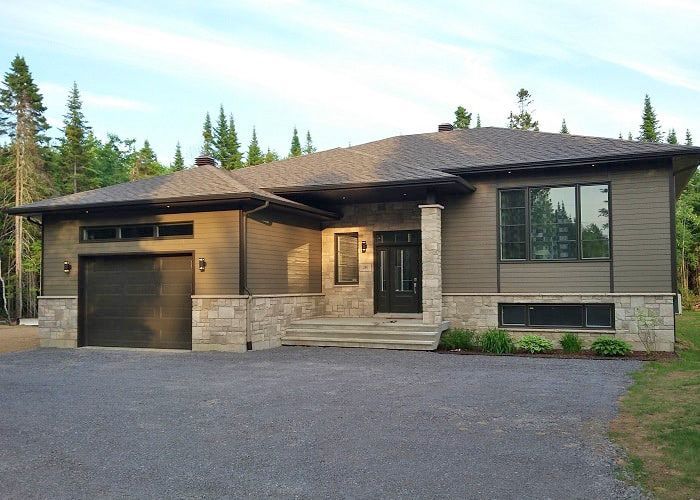 Une grande maison avec un garage et une allée devant
