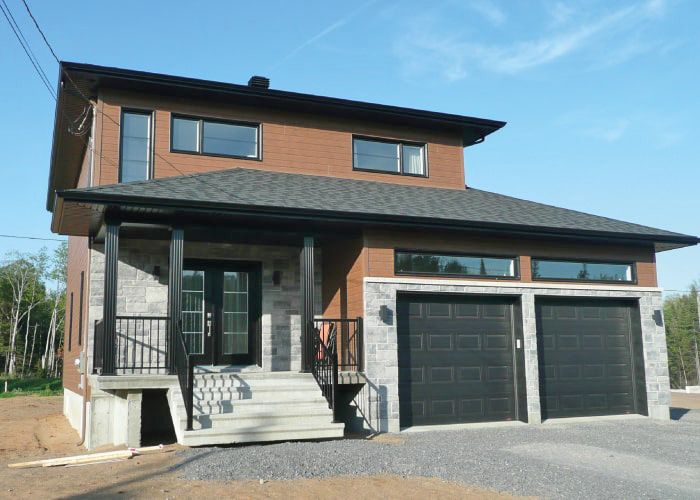 Une grande maison avec deux garages et un porche