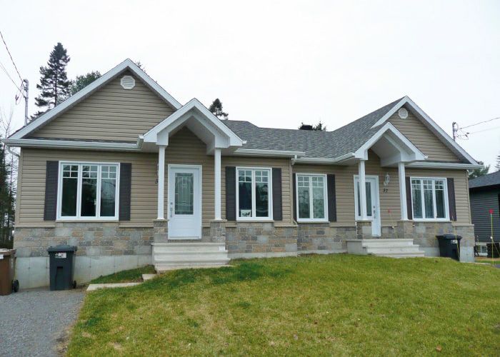 Une maison avec beaucoup de fenêtres et de volets