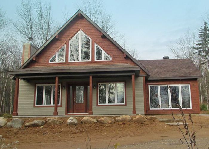 Une maison avec un toit rouge et beaucoup de fenêtres