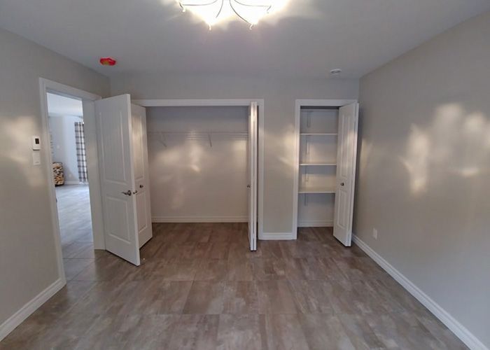 Une pièce vide avec parquet et deux placards.