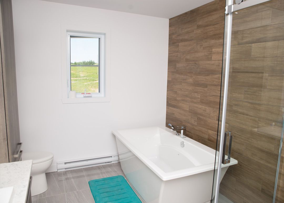 Une salle de bain avec baignoire, WC, lavabo et douche.
