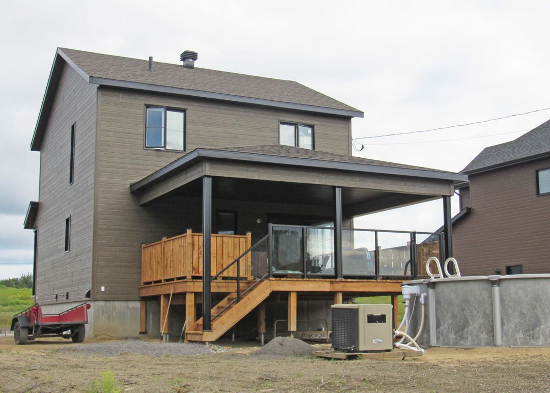 L'arrière d'une maison avec une terrasse et des escaliers