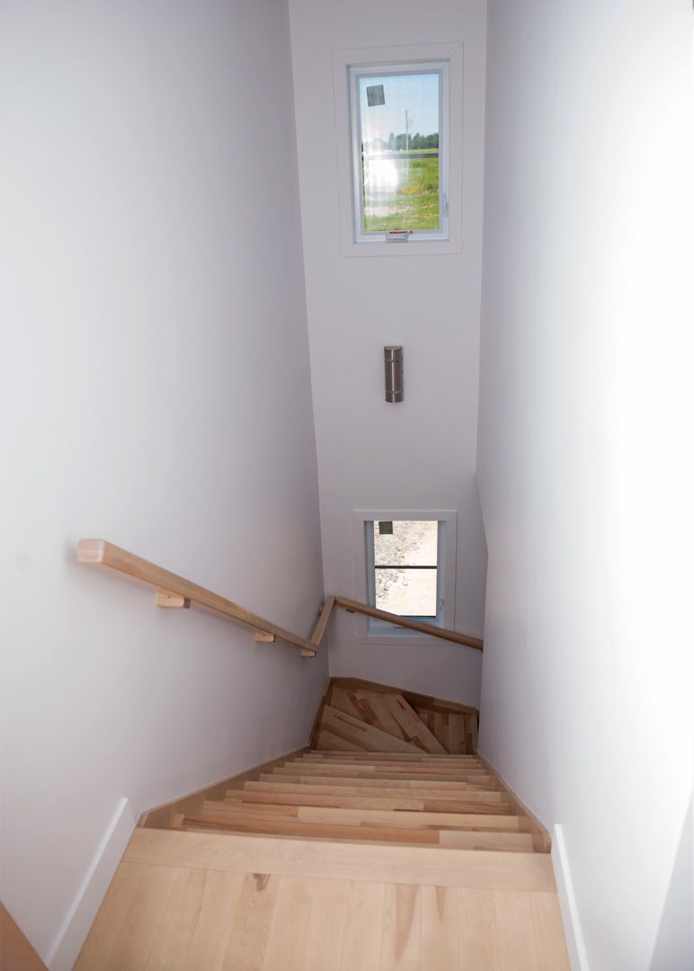 Un escalier en bois menant à une fenêtre