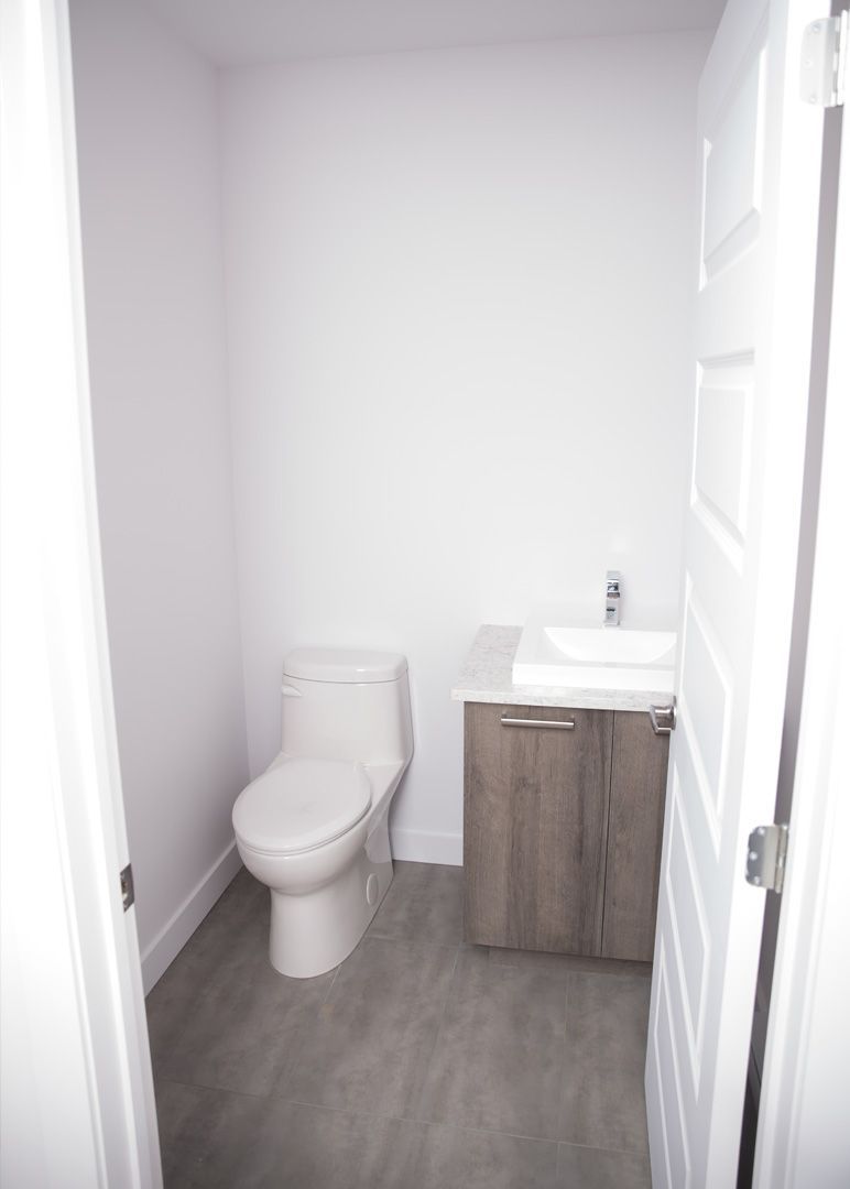 Une salle de bain avec WC, lavabo et meuble de rangement.