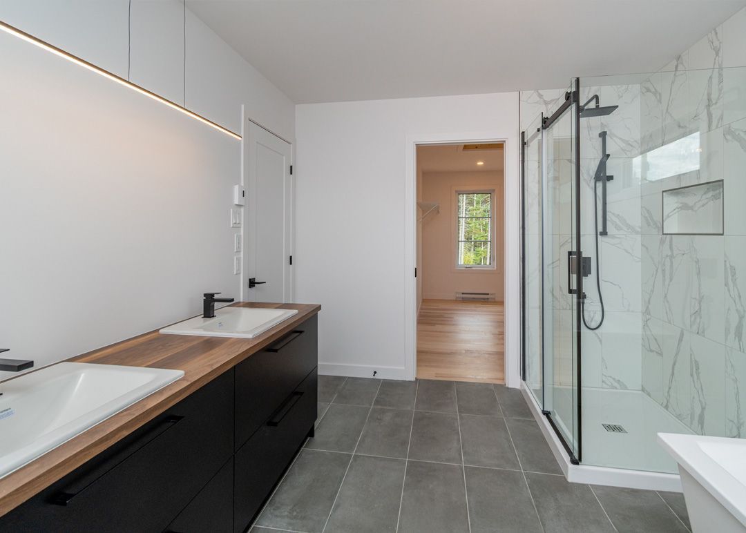 Une salle de bain avec deux vasques et une douche à l'italienne.