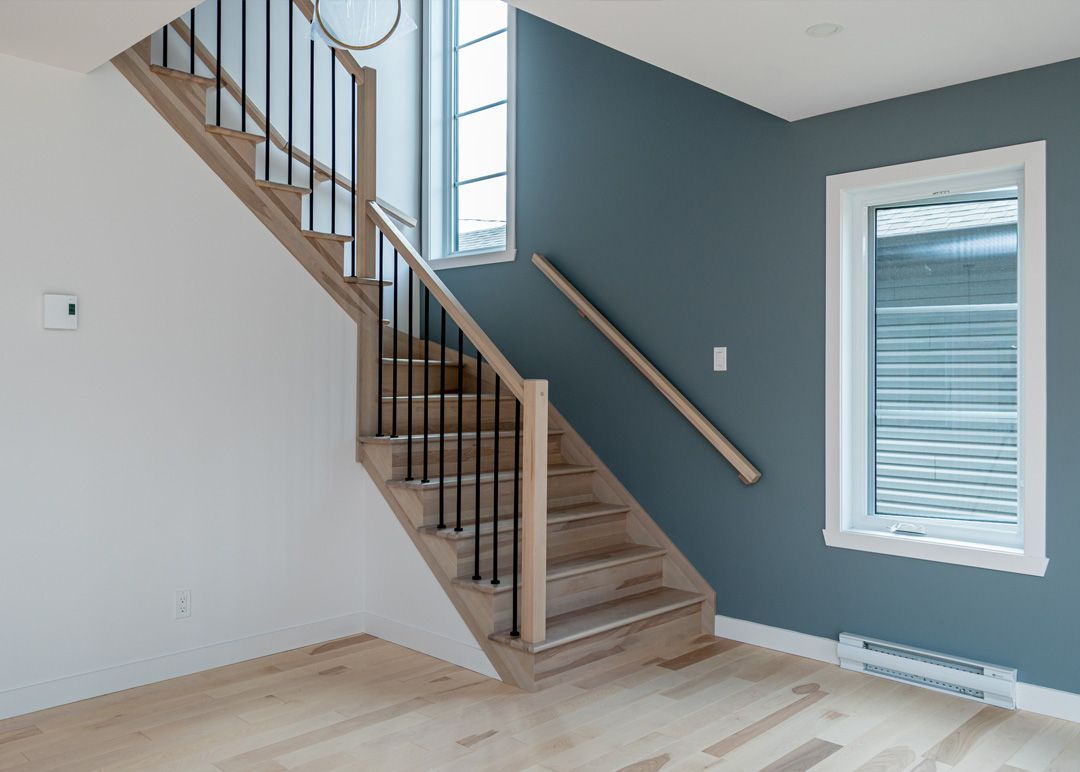 Une pièce vide avec un escalier et une fenêtre