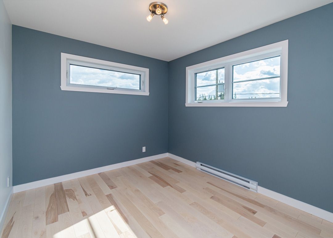 Une pièce vide avec des murs bleus et du parquet