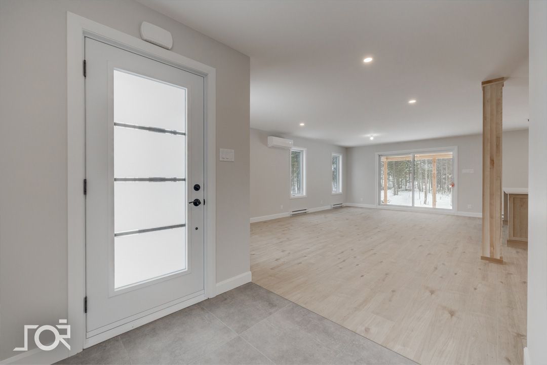 Une pièce vide avec une porte blanche et du parquet