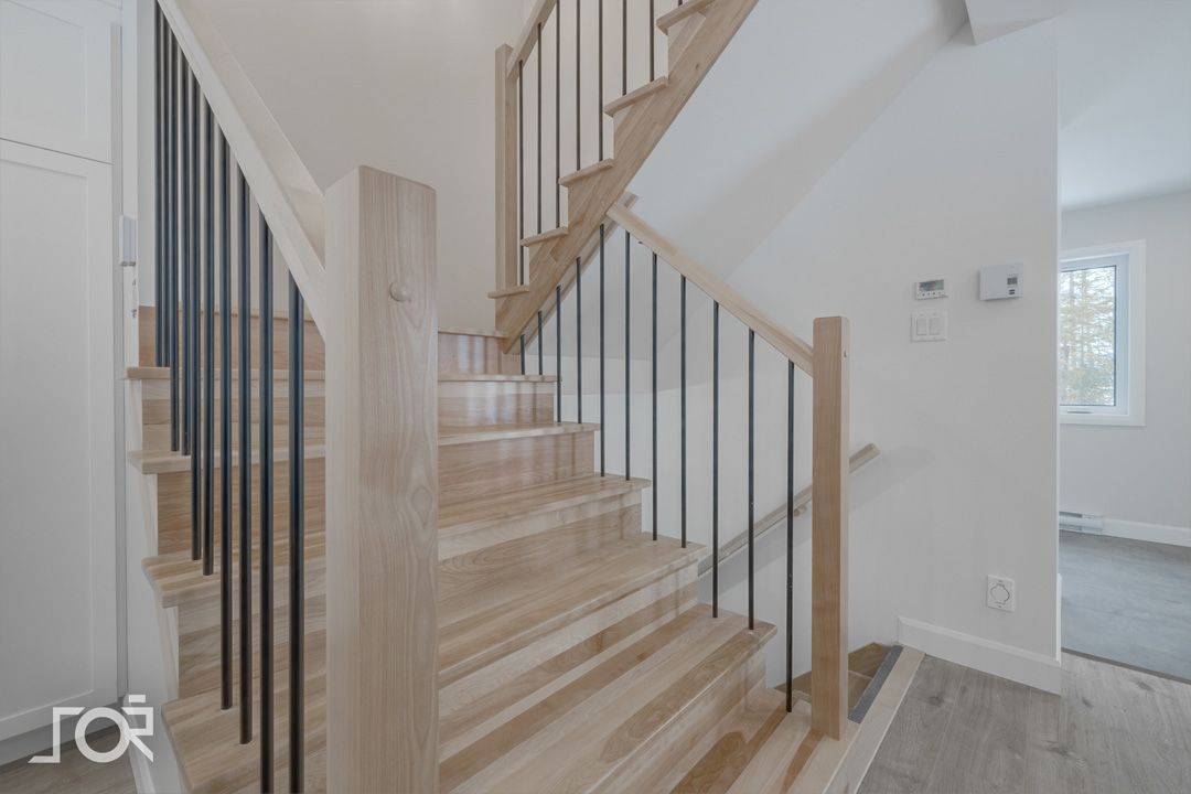 Un escalier en bois avec une rampe en métal dans une maison.